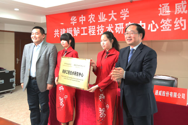 股份严虎总裁（右一）与华中农业大学副校长陈兴荣（左一）配合为“鳜鲈工程手艺研究中心”揭牌